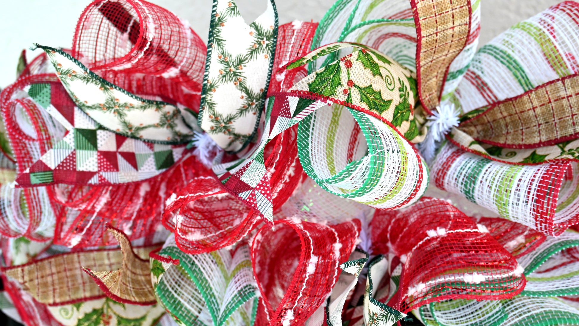 a close up of a christmas wreath with ribbons