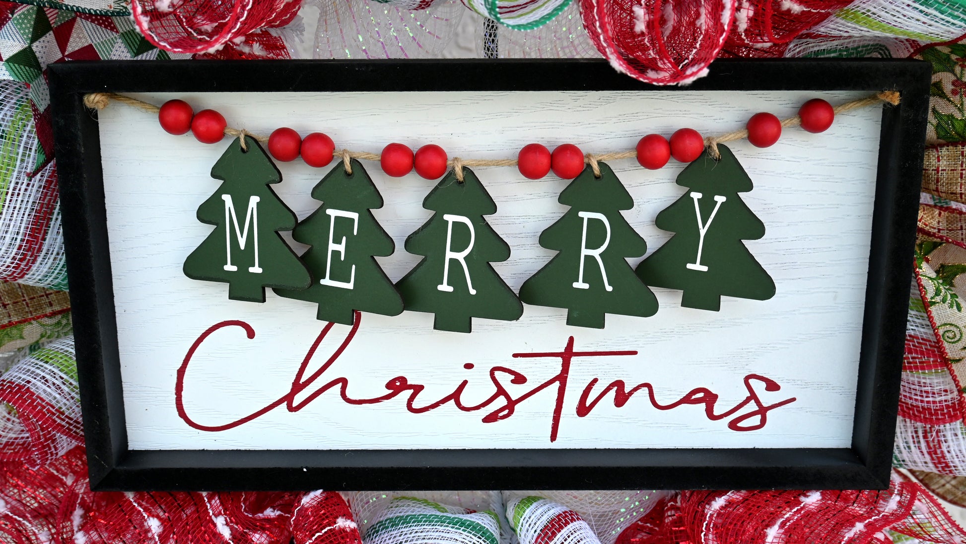 a picture of a merry christmas sign hanging on a wall