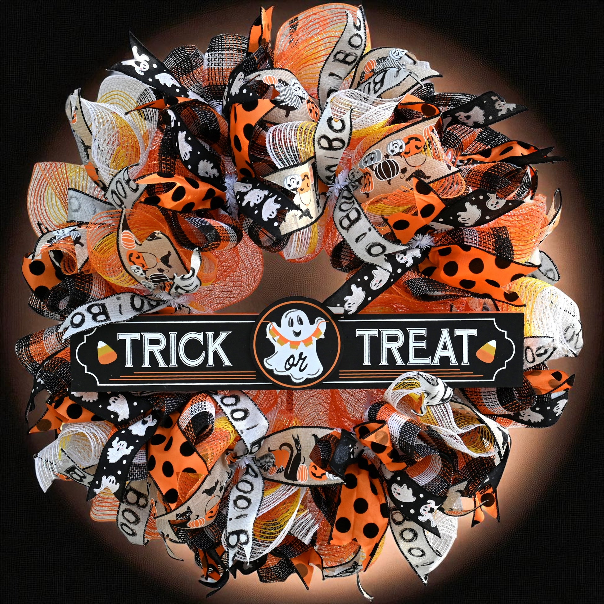 A vibrant Trick or Treat Wreath featuring a playful ghost and adorned with colorful ribbons, perfect for Halloween decoration.