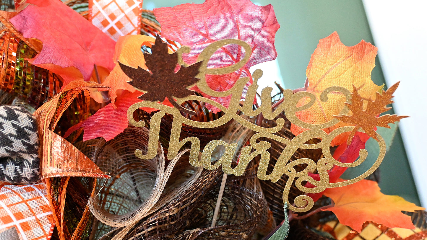 a basket filled with fall leaves and a happy thanksgiving sign