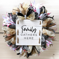 Family Gathers Here wreath hanging on a front door with rose, gold, black, burlap and white ribbon accents for fall decor.
