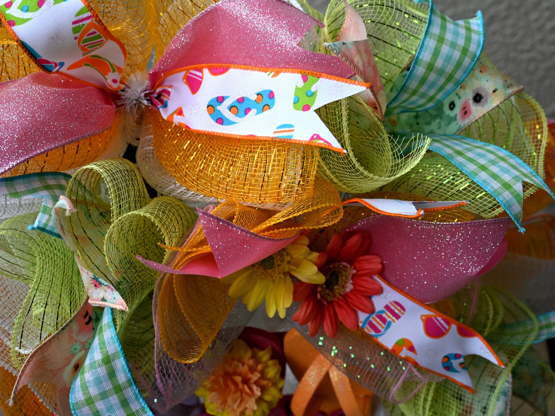 a close up of a colorful wreath with ribbons