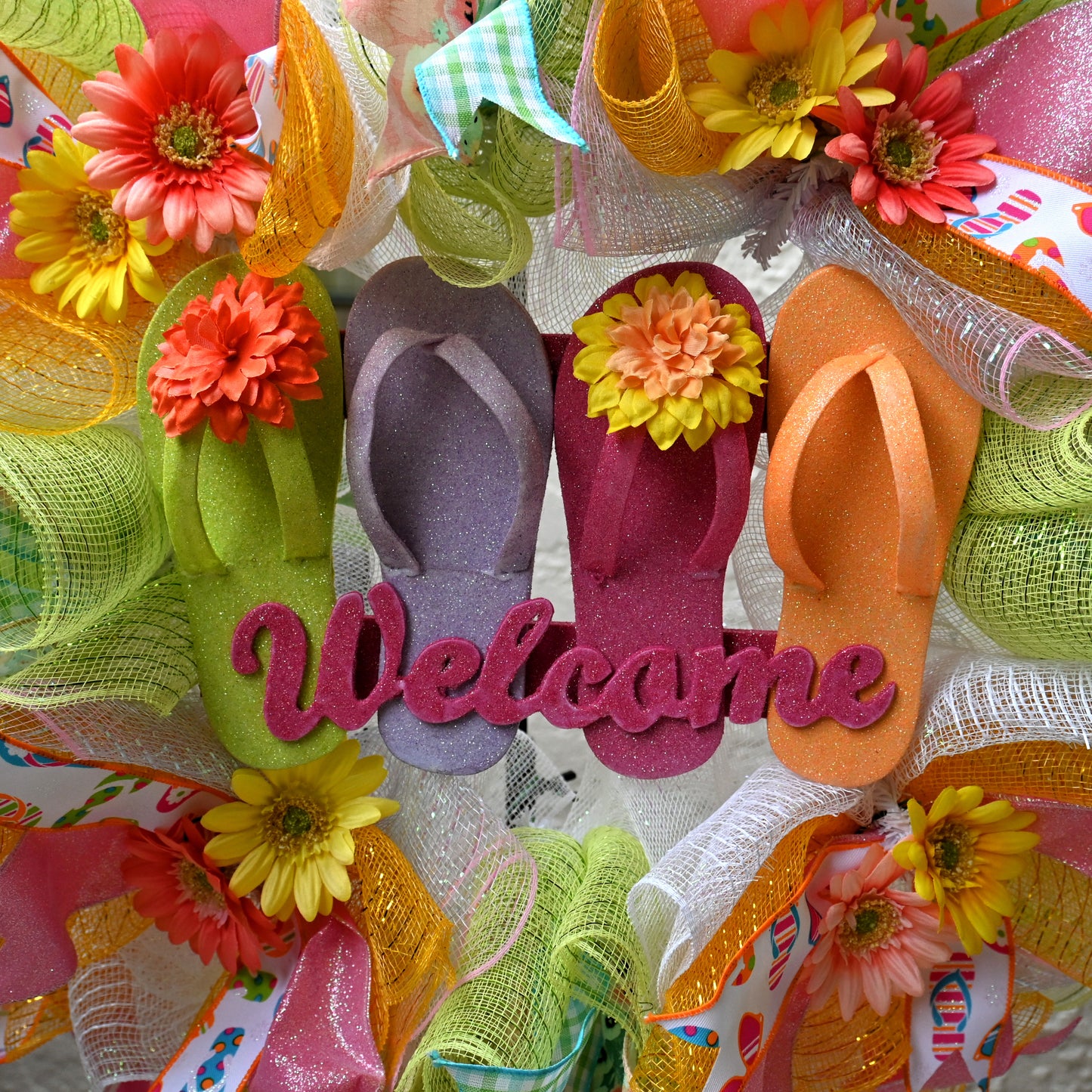 a welcome wreath with a pair of flip flops and flowers