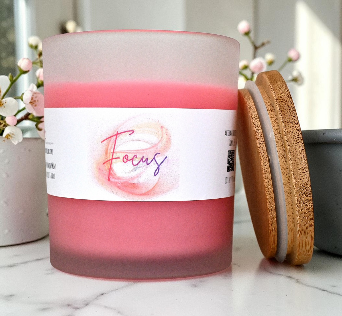 Focus candle in pink frosted glass jar with bamboo lid removed, showing pink wax