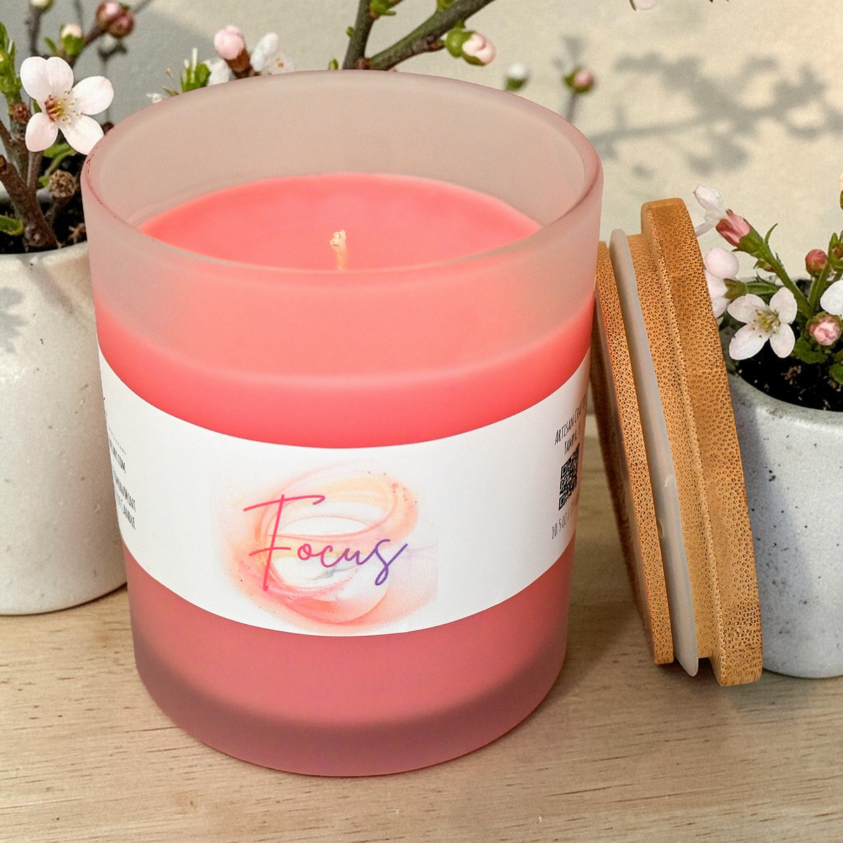 Top view of open Focus candle with pink wax and wick beside bamboo lid