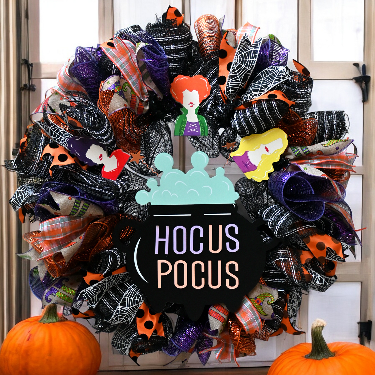 Hocus Pocus Halloween wreath with witches, cauldron, and black, purple, orange and white ribbons for front door decor.