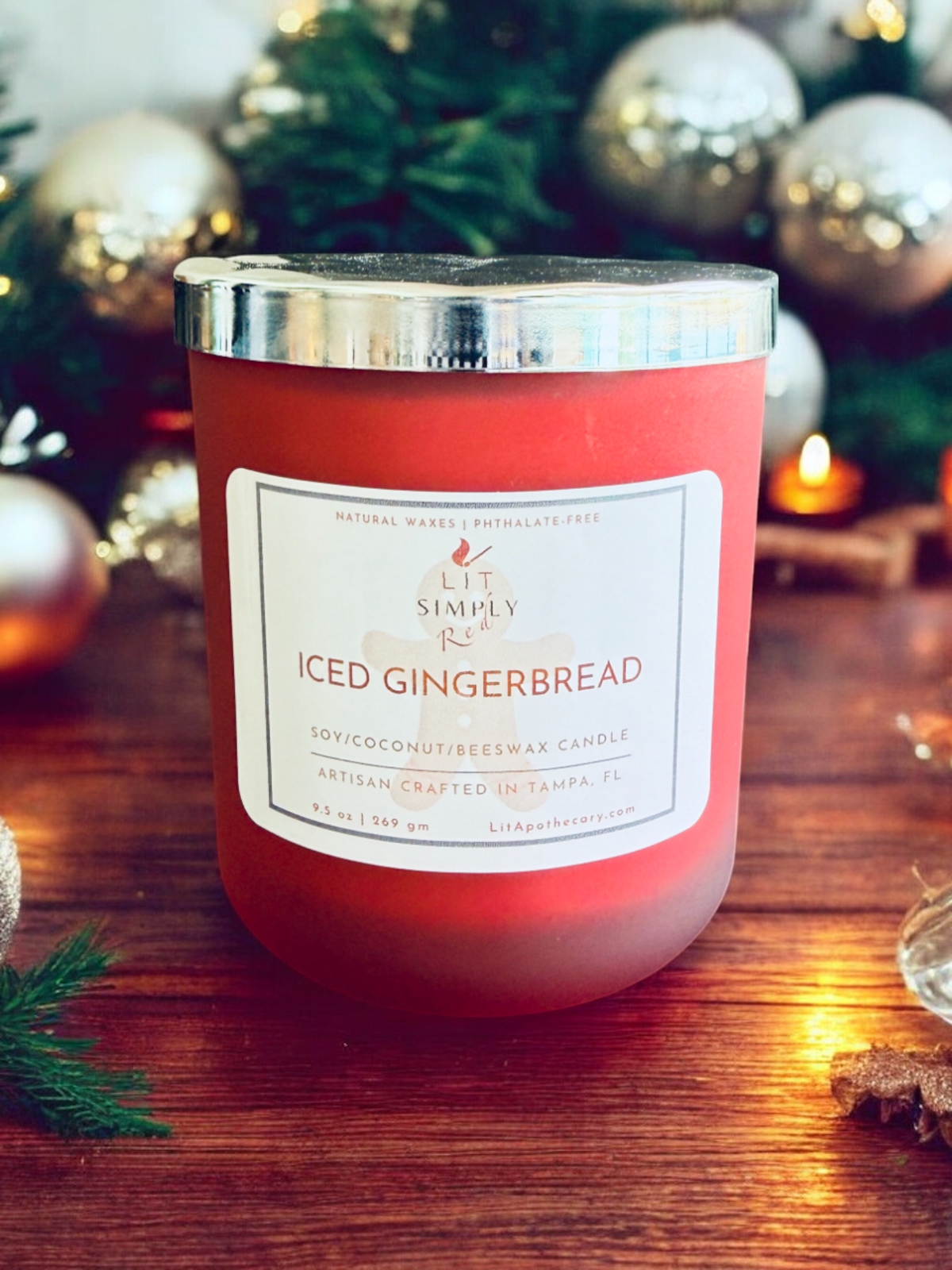 Iced Gingerbread Christmas candle in a red luxury jar with decorative lid, styled beside a Christmas tree for festive holiday home fragrance.