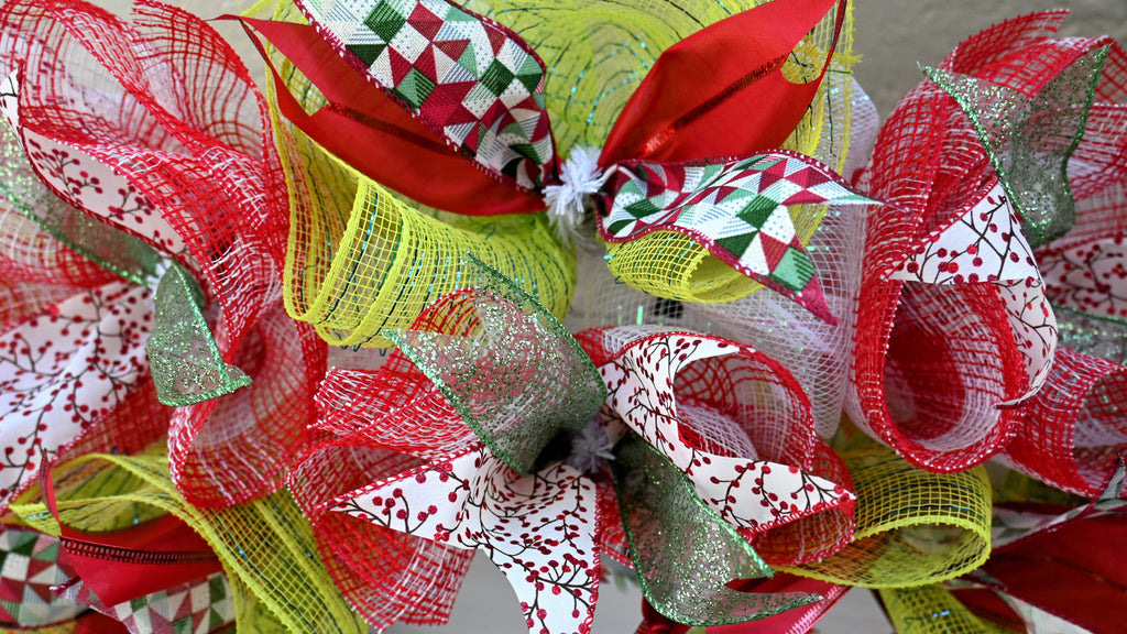 a close up of a red and green wreath