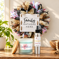 Family Gathers Here wreath above a wooden console with a Spa Hibiscus candle and Mango Breeze room spray from LIT Apothecary.
