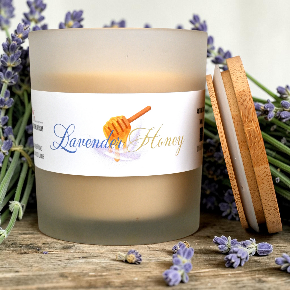 Candle labeled 'Lavender Honey' with lavender flowers and wooden coasters on a wooden surface.