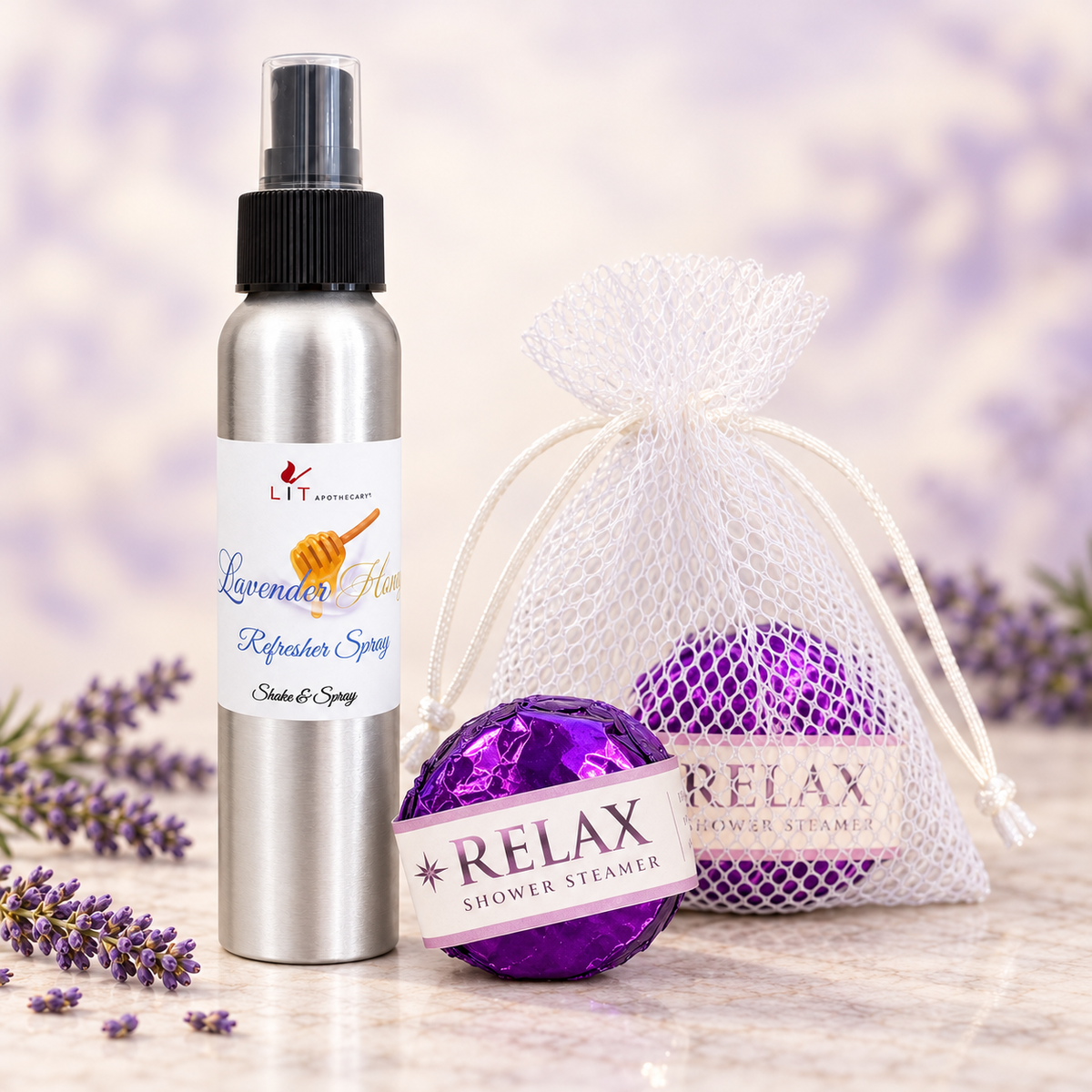 LIT Apothecary Self-Care Bundle featuring Lavender Honey Refresher Spray and purple foil-wrapped RELAX shower steamers with a white mesh pouch, displayed beside lavender sprigs.