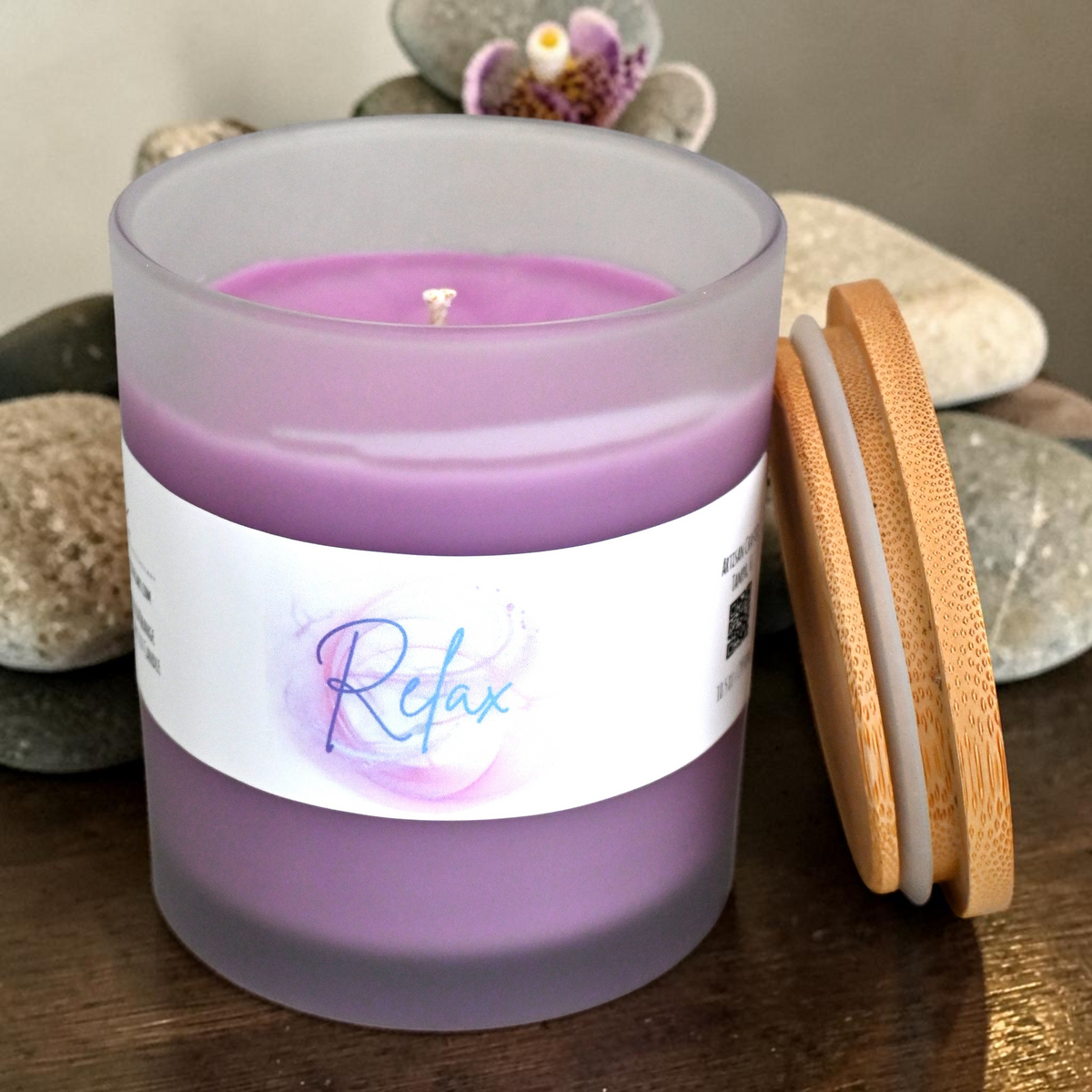 Top view of open Relax candle showing purple wax and wick beside bamboo lid