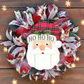 Santa Christmas wreath with cheerful Santa face, Ho Ho Ho plaid hat, and layered red, green and white holiday ribbons.