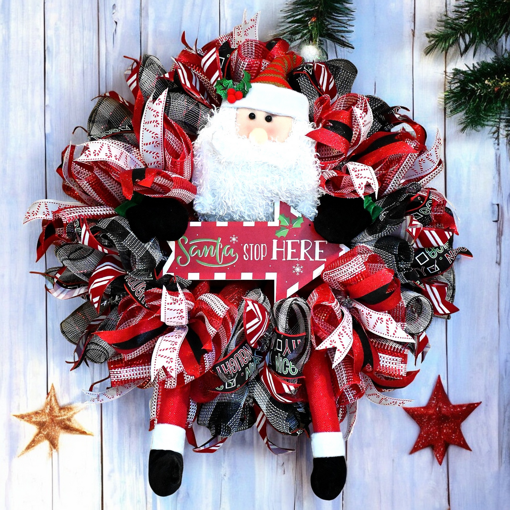 Santa Stop Here Christmas wreath with Santa figure, red white and black ribbons, and festive front door decor.