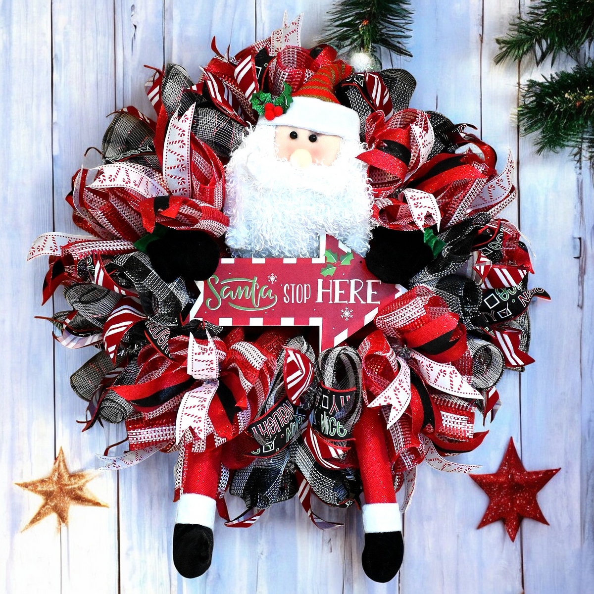 Santa Stop Here Christmas wreath with Santa figure, red white and black ribbons, and festive front door decor.