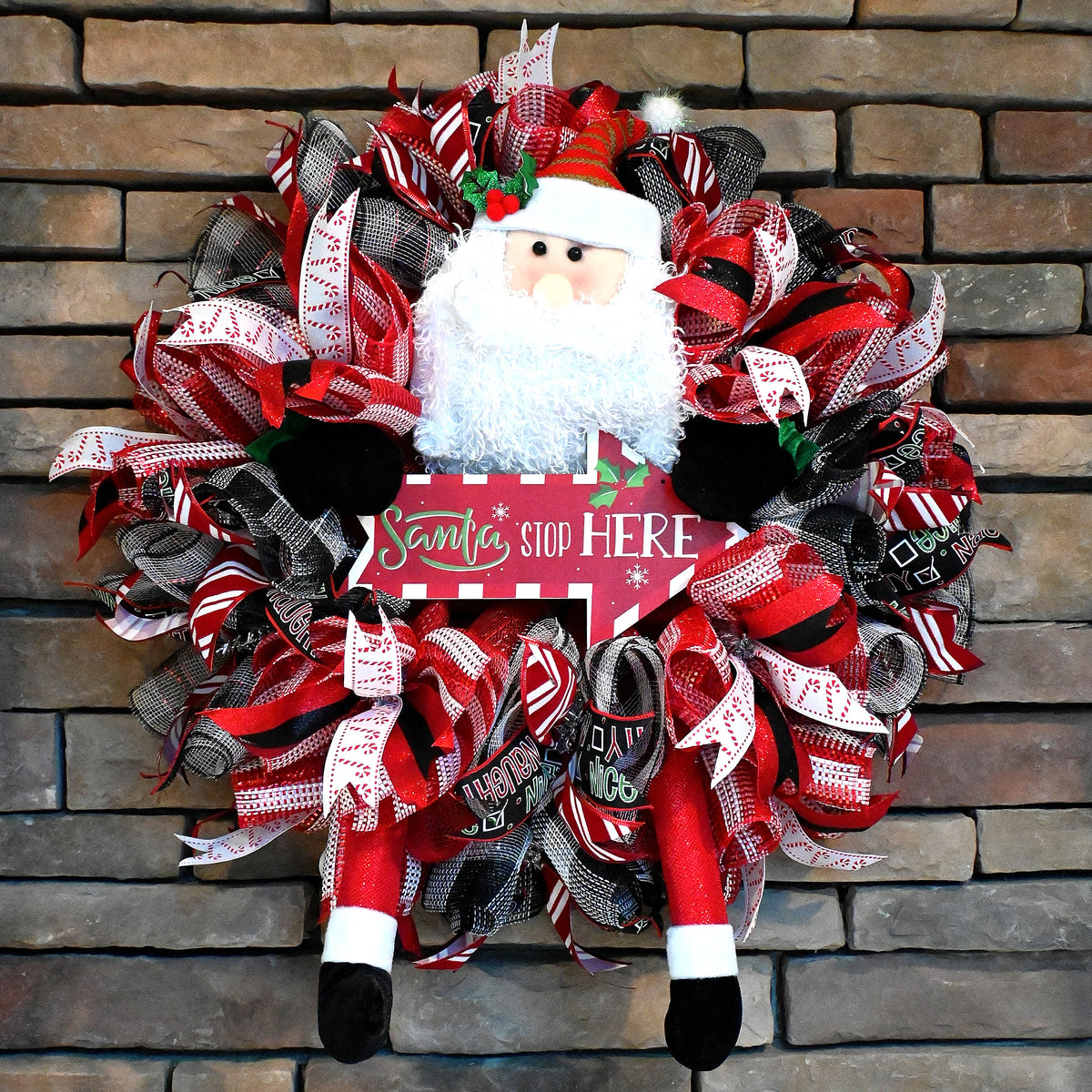 Santa Stop Here Christmas wreath with layered holiday ribbons and cheerful Santa front door decoration.