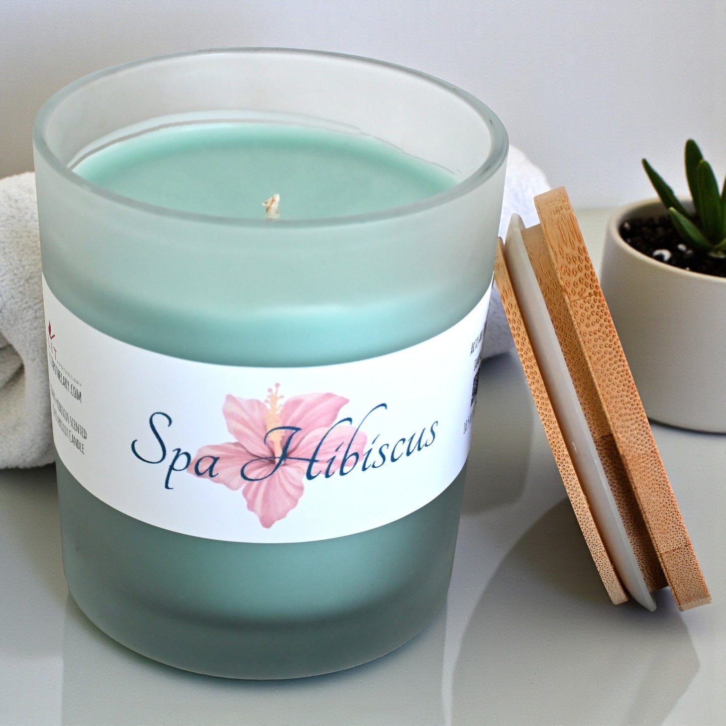 Spa Hibiscus Candle from Lit Apothecary, featuring agave and hibiscus scents in a frosted jar with a bamboo lid.