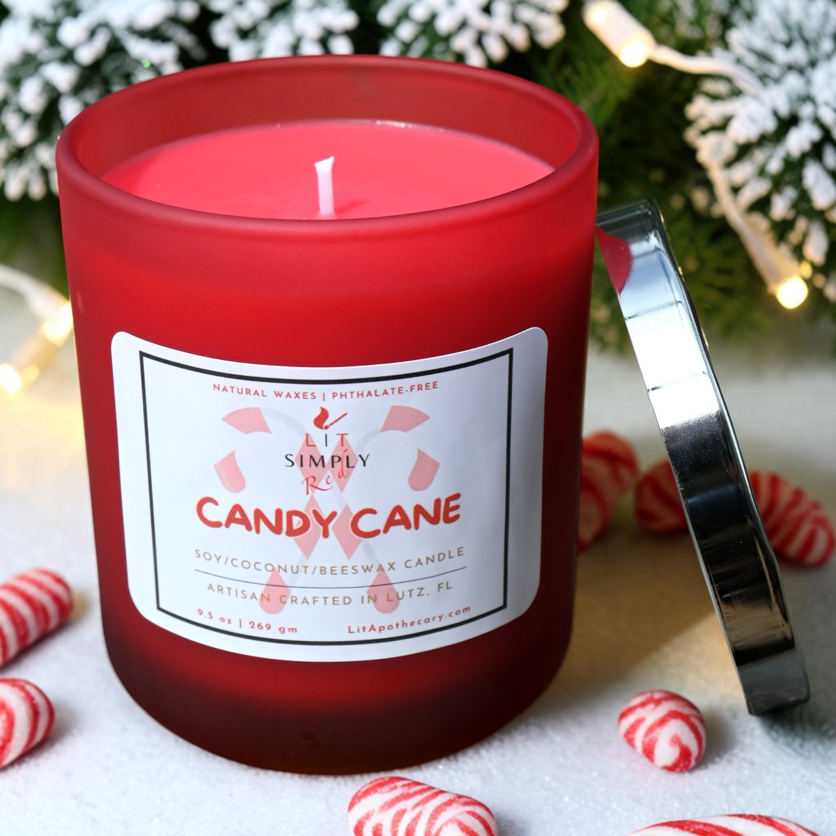 Angled top view of Candy Cane candle showing pink wax and a single cotton wick in a red frosted glass jar.