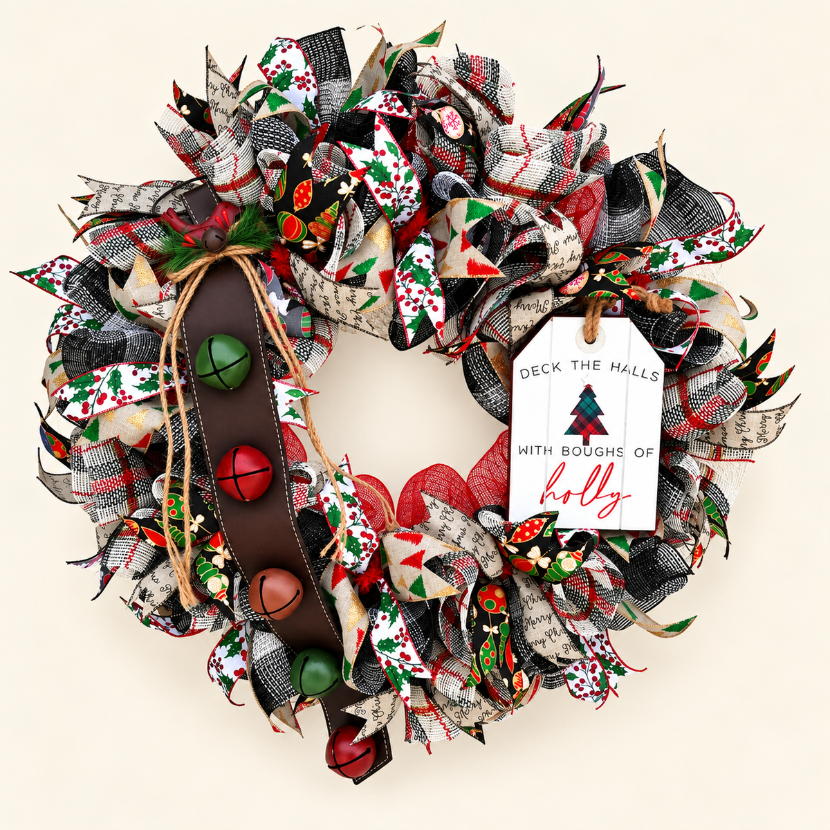 Deck the Halls Christmas wreath with patterned ribbons, a white holly sign, and jingle bells on a brown leather strap