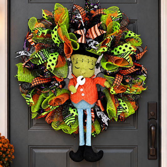 Handmade Frankenstein Halloween wreath with green, orange and black deco mesh on a charcoal front door