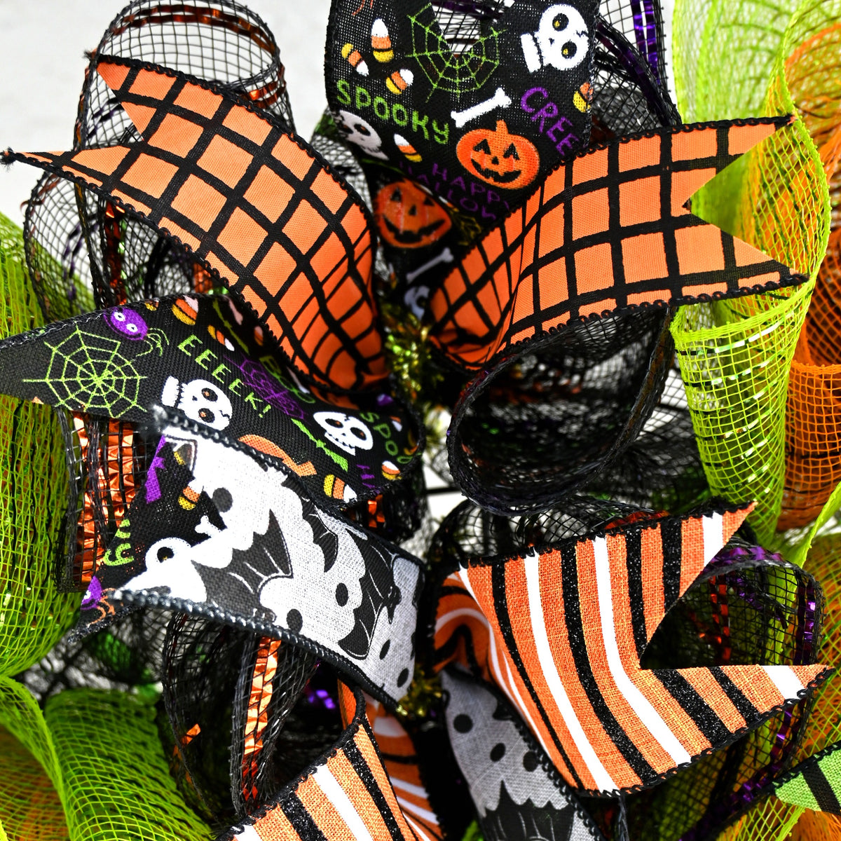 Close-up of Halloween ribbons and lime green, orange and black deco mesh on Frankenstein wreath