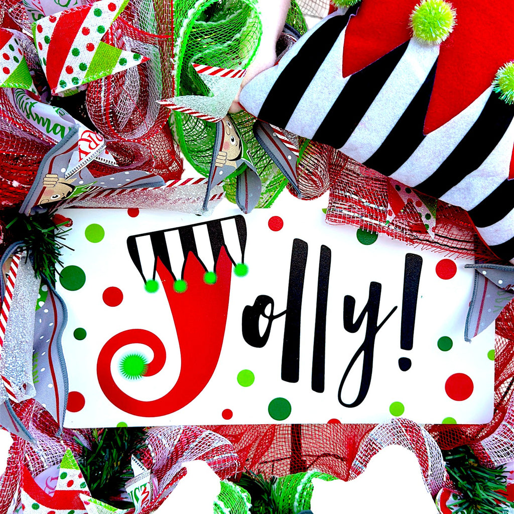 Jolly sign with red and green polka dots at the center of the Christmas elf wreath.