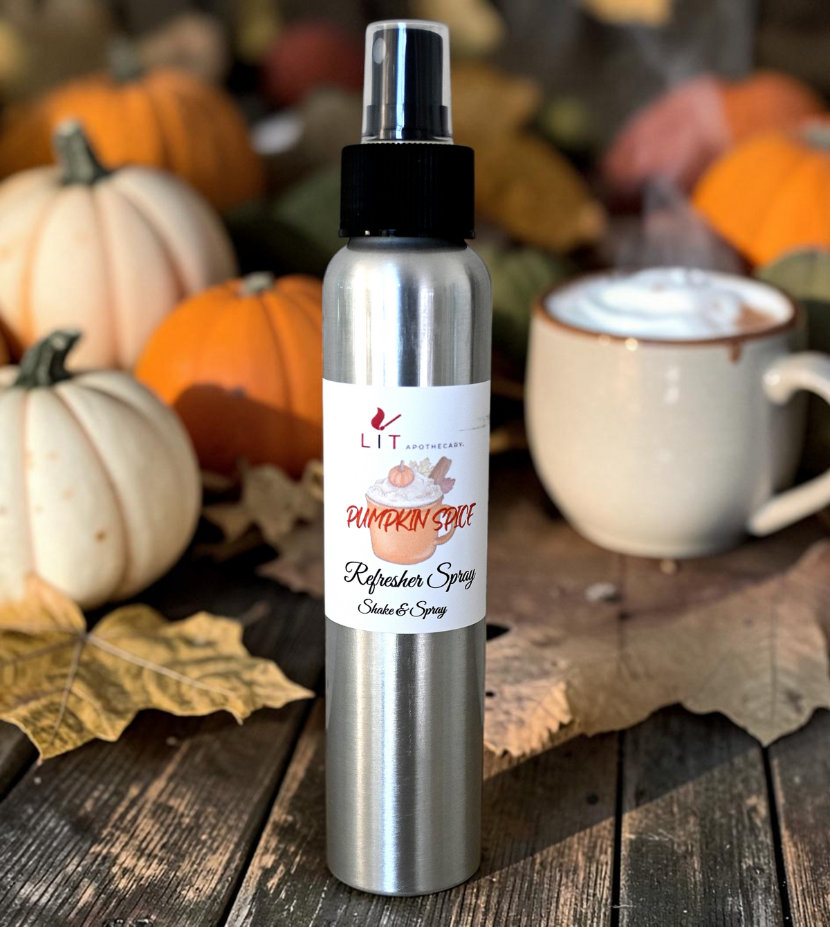 Lit Apothecary Pumpkin Spice room spray displayed with fall pumpkins, leaves and a cozy drink