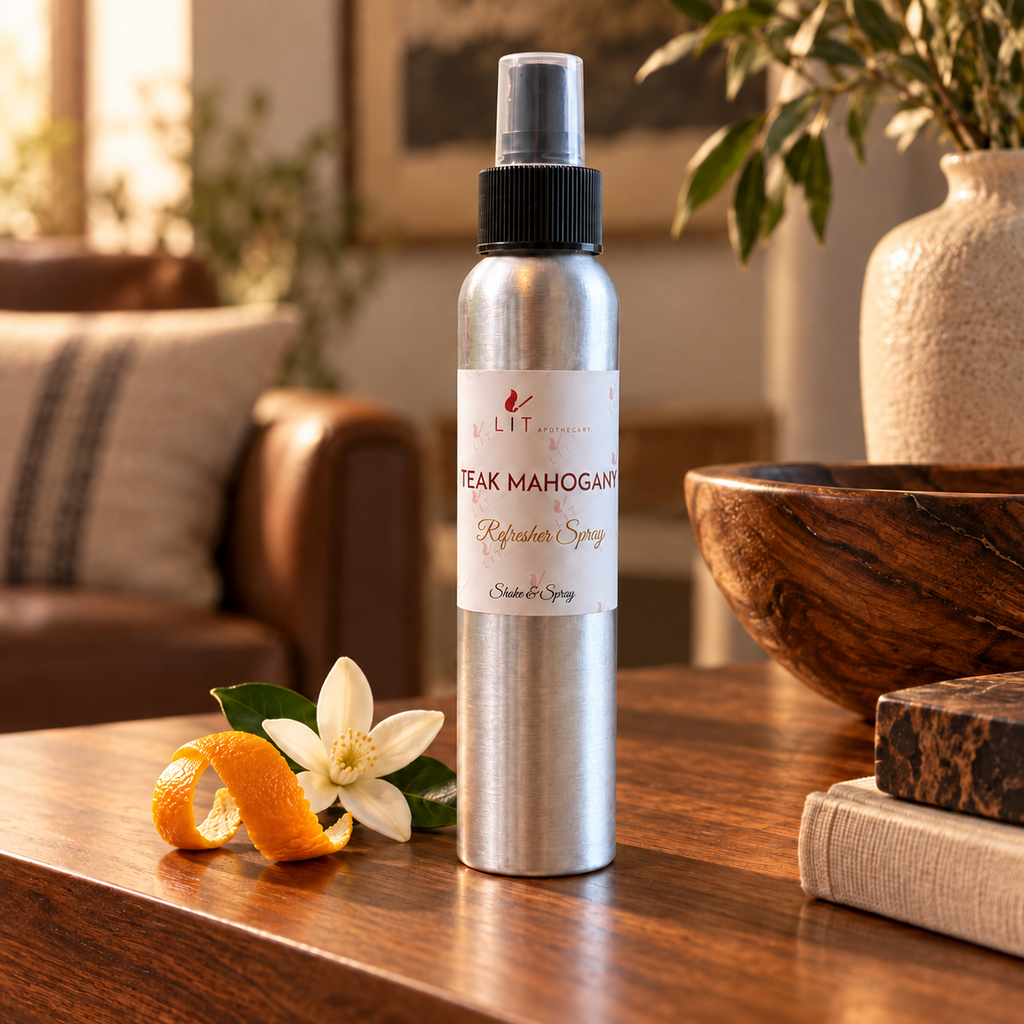 Teak Mahogany room spray displayed with wood, citrus peel and a cream blossom