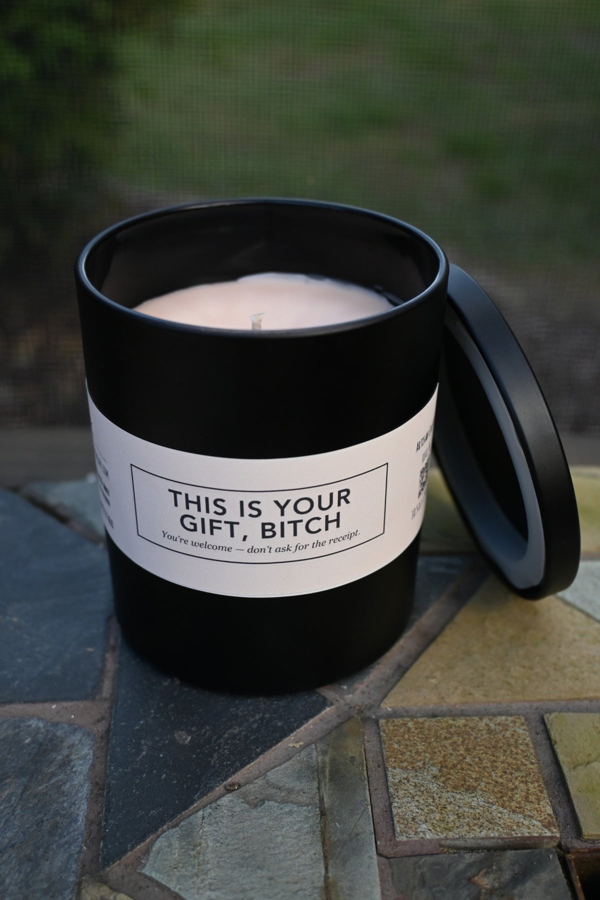 Original unedited photograph of actual matte black candle open showing cream wax