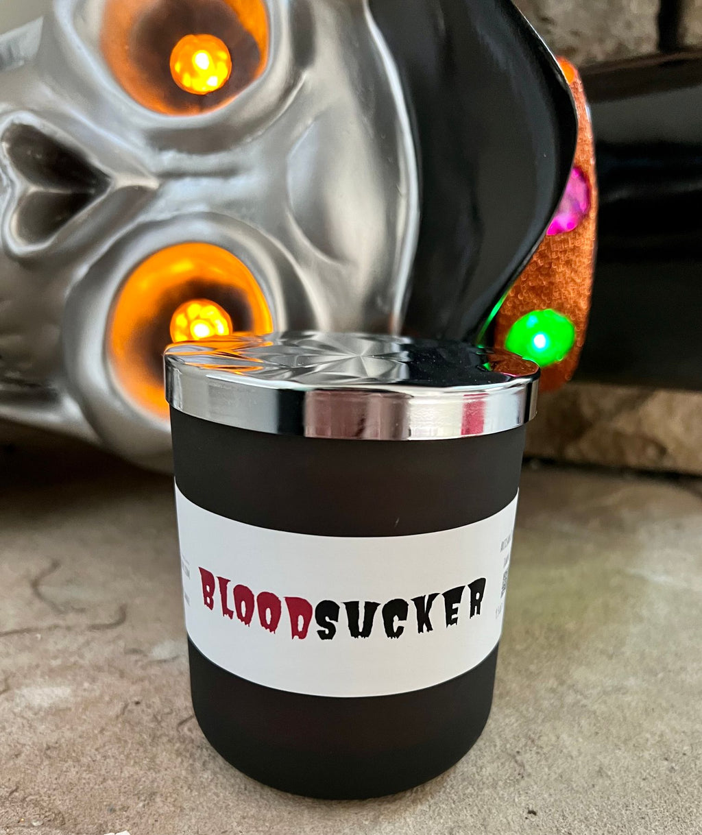 Bloodsucker Halloween candle with a patterned silver lid and red-and-black label