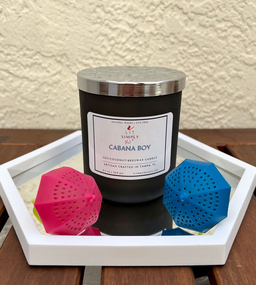 Cabana Boy candle closed in previous dark matte jar with silver patterned lid; photo shows former 9.5 oz soy, coconut and beeswax label
