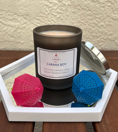 Cabana Boy tropical coconut candle open in previous dark matte jar, beside its silver lid; photo shows former 9.5 oz soy, coconut and beeswax label