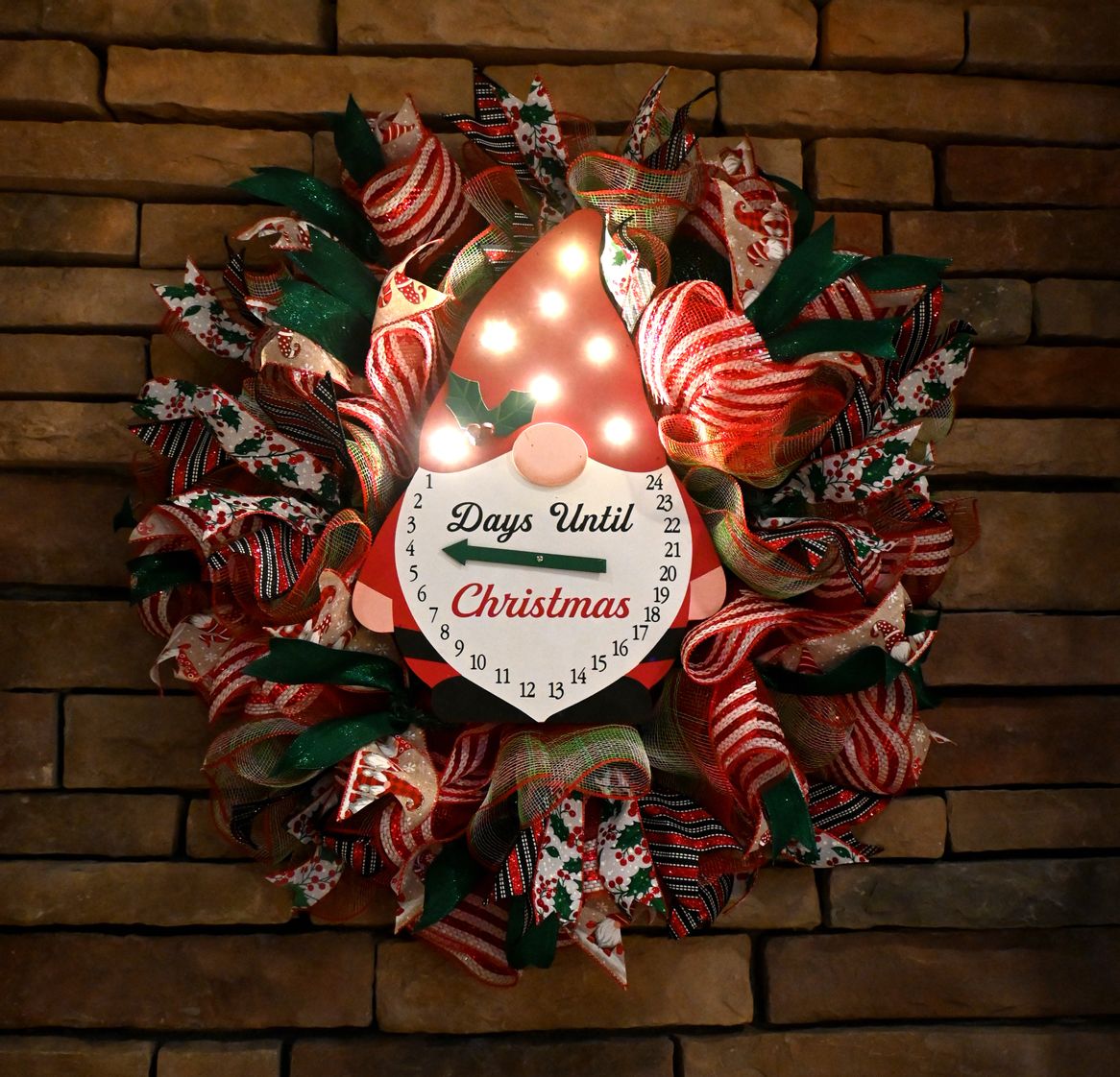 Lighted gnome Christmas countdown wreath glowing against a dark background