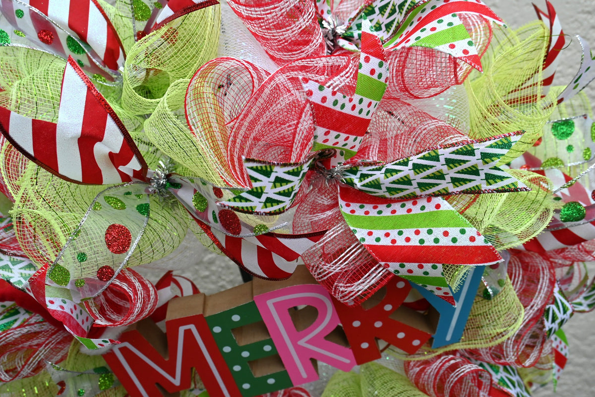 Close-up of striped, glitter-dot and Christmas tree ribbons on the Merry holiday wreath