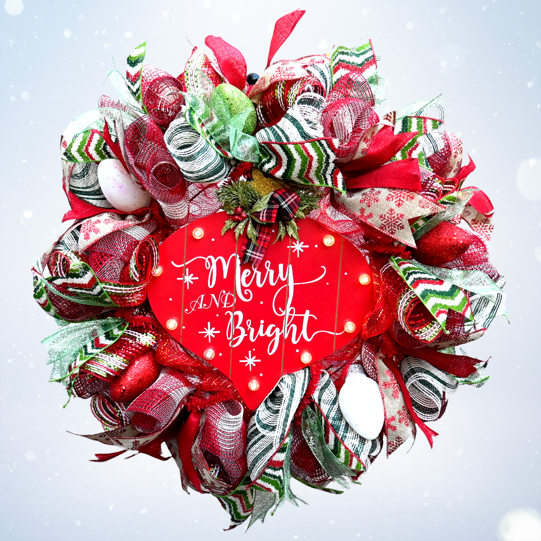 Merry and Bright lighted Christmas wreath with colorful bulb ornaments in a snowy holiday setting