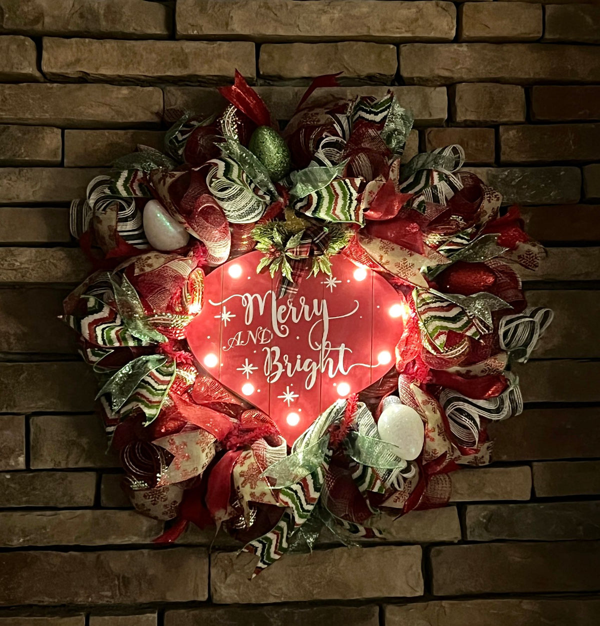 Lighted Merry and Bright holiday wreath displayed against a dark background