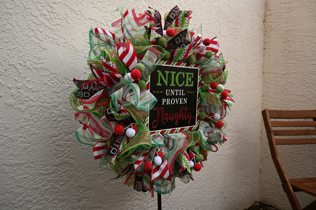 Left-side detail of the Nice Until Proven Naughty Christmas door wreath