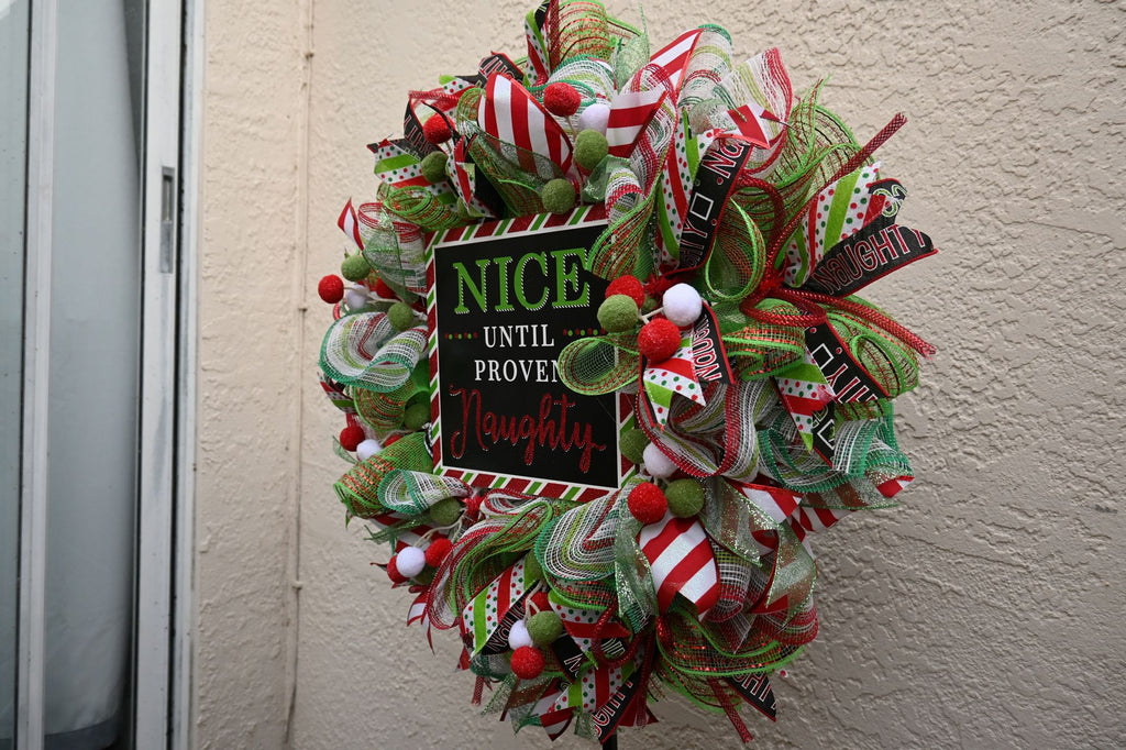 Right-side detail of the Naughty Nice wreath with red mesh and glitter ribbon
