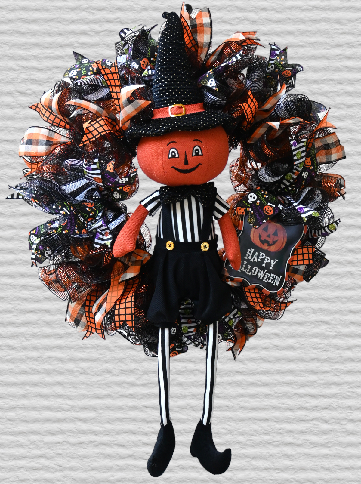 Pumpkinhead Halloween wreath with Happy Halloween sign, orange, black and white ribbons, and playful pumpkin front door decor.