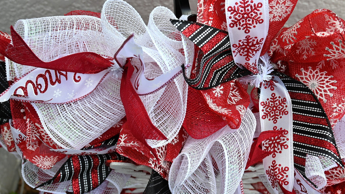 Ribbon detail on Winter Snowflake Wreath with black, red and white stripes and glittery snowflake accents.