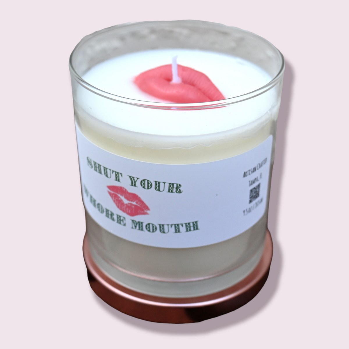 Open Shut Your Whore Mouth candle in clear glass jar with red lips wax accent and rose-gold-tone lid beneath